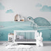 Une chambre d'enfant avec un papier peint aquatique illustrant une tortue et des bateaux sur fond bleu pastel, créant une atmosphère douce et ludique.