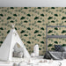 Une chambre d'enfant avec un papier peint illustrant des tortues vertes et des feuillages sur fond beige, créant une ambiance douce et naturelle.