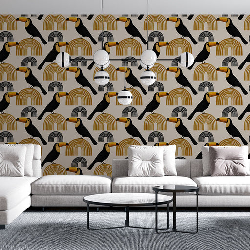 Un salon moderne avec un papier peint coloré représentant des toucans noirs et des arcs-en-ciel dorés sur fond beige, créant une ambiance joyeuse et tropicale.
