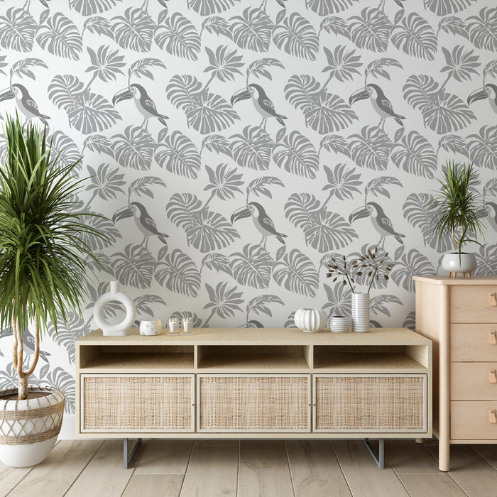 Une pièce moderne avec un papier peint tropical gris clair illustrant des feuilles exotiques et des toucans, créant une ambiance à la fois fraîche et apaisante.
