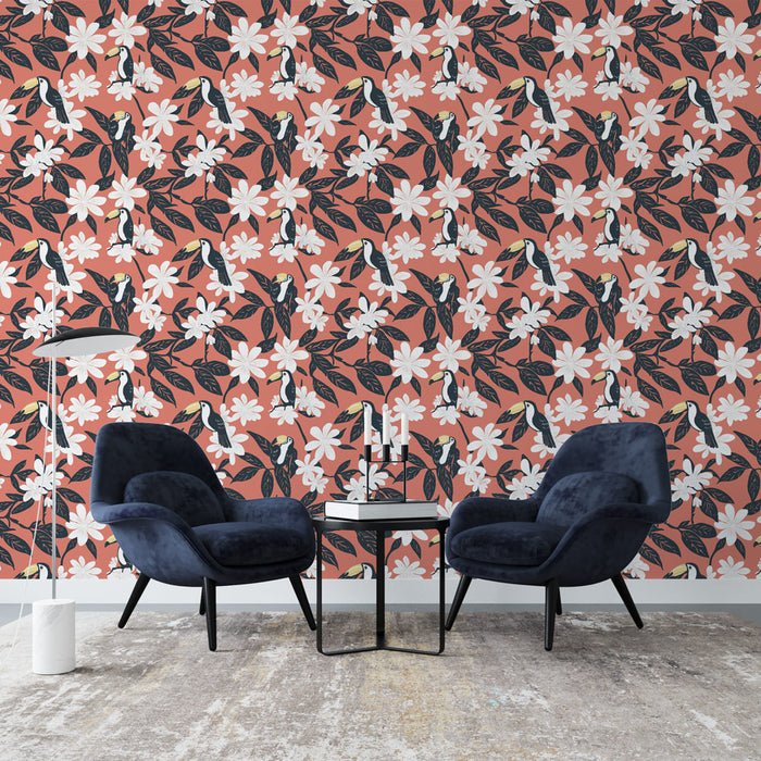 Un salon moderne avec un papier peint tropical aux motifs de toucans et de fleurs blanches sur fond corail, créant une ambiance vivante et chaleureuse.