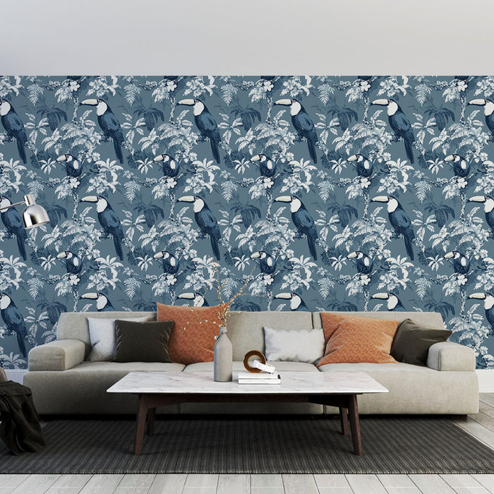 Un salon moderne avec un papier peint tropical bleu représentant des toucans et des feuillages luxuriants, créant une atmosphère vivante et exotique.