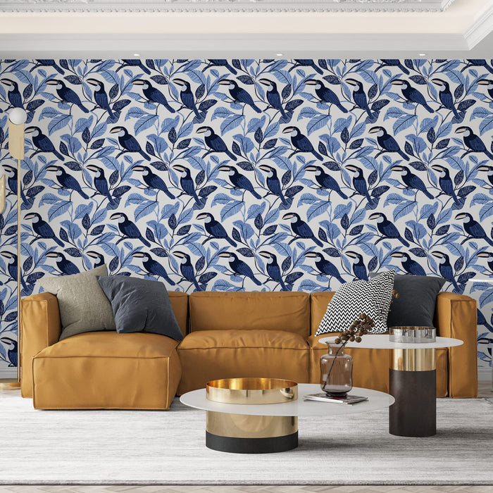 Un salon contemporain avec un papier peint floral bleu et blanc illustrant des oiseaux stylisés parmi des feuillages, créant une ambiance fraîche et apaisante.