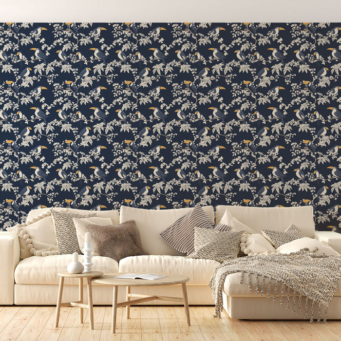 Un salon lumineux avec un papier peint floral bleu marine orné de motifs d'oiseaux et de fleurs blanches, créant une ambiance exotique et apaisante.