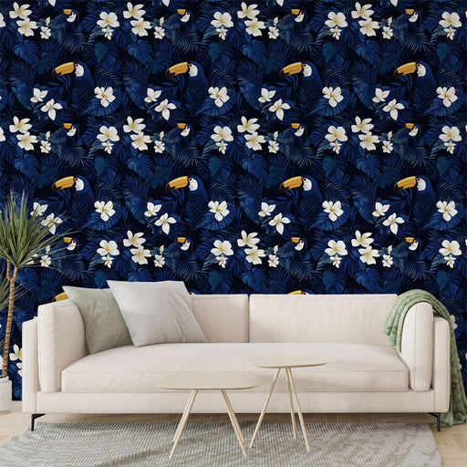 Un salon contemporain avec un papier peint tropical bleu nuit orné de toucans et de fleurs blanches, créant une ambiance exotique et vivante.
