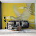 Un salon moderne avec un papier peint jaune vif représentant des toucans stylisés en vol, créant une ambiance dynamique et tropicale.