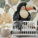 Une chambre d'enfant avec un papier peint illustrant un toucan souriant entouré de grandes feuilles aux teintes douces, créant une atmosphère joyeuse et apaisante.