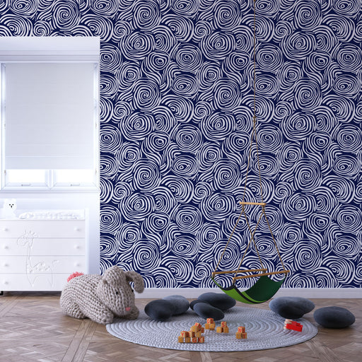 Une chambre enfantine avec un papier peint bleu marine orné de motifs spirales blanches, créant une ambiance dynamique et ludique.