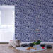Une chambre enfantine avec un papier peint bleu marine orné de motifs spirales blanches, créant une ambiance dynamique et ludique.
