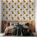 Une chambre chaleureuse avec un papier peint floral représentant des tournesols jaunes sur fond clair, créant une ambiance lumineuse et accueillante.
