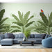 Un salon moderne avec un papier peint tropical représentant de grandes feuilles vertes et un perroquet coloré, créant une atmosphère vivante et apaisante.