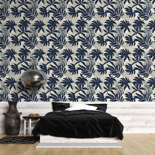 Une chambre moderne avec un papier peint tropical aux motifs de grandes feuilles bleu marine sur fond clair, créant une ambiance rafraîchissante et naturelle.