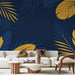 Un salon moderne avec un papier peint tropical bleu nuit orné de grandes feuilles jaunes et vertes, créant une ambiance chaleureuse et accueillante.