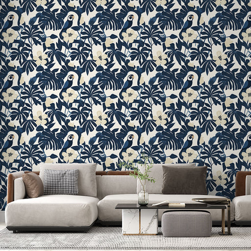 Un salon moderne avec un papier peint tropical bleu marine illustrant des toucans et des feuillages luxuriants sur fond clair, créant une ambiance vivante et accueillante.