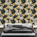 Une chambre moderne avec un papier peint tropical aux motifs de grandes feuilles noires, blanches et dorées créant une ambiance élégante et chaleureuse.