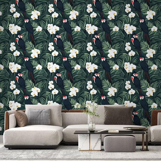 Un salon moderne avec un papier peint tropical représentant des perroquets noirs et des fleurs blanches sur un fond vert, créant une ambiance vivante et exotique.