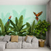 Un salon lumineux avec un papier peint tropical représentant de grandes feuilles vertes et des perroquets colorés, créant une ambiance vivante et exotique.