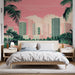 Une chambre moderne avec un papier peint tropical représentant une ville en rose et vert, entourée de palmiers, créant une ambiance estivale et dynamique.