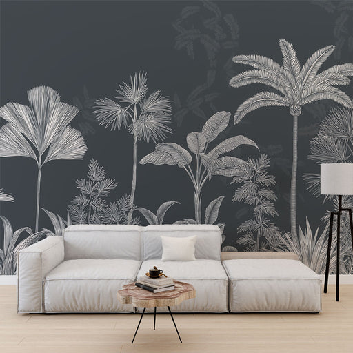 Un salon moderne avec un papier peint tropical noir illustrant des feuillages blancs, créant une ambiance élégante et apaisante.