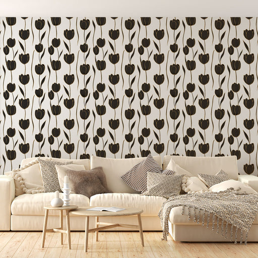 Un salon élégant avec un papier peint floral noir et or représentant des tulipes stylisées sur fond clair, créant une atmosphère raffinée et chaleureuse.