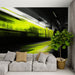 Une salle de séjour contemporaine avec un papier peint abstrait représentant un train en mouvement, mêlant des teintes de noir et de vert vif, créant une ambiance dynamique et urbaine.