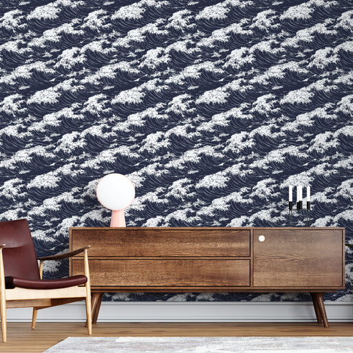 Un salon moderne avec un papier peint représentant des vagues blanches sur fond bleu marine, créant une atmosphère dynamique et apaisante.