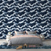 Une chambre moderne avec un papier peint représentant des vagues stylisées en bleu marine et blanc, créant une ambiance dynamique et apaisante.