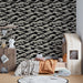 Une chambre d'enfant avec un papier peint représentant des vagues stylisées en beige sur fond noir, créant une ambiance dynamique et ludique.