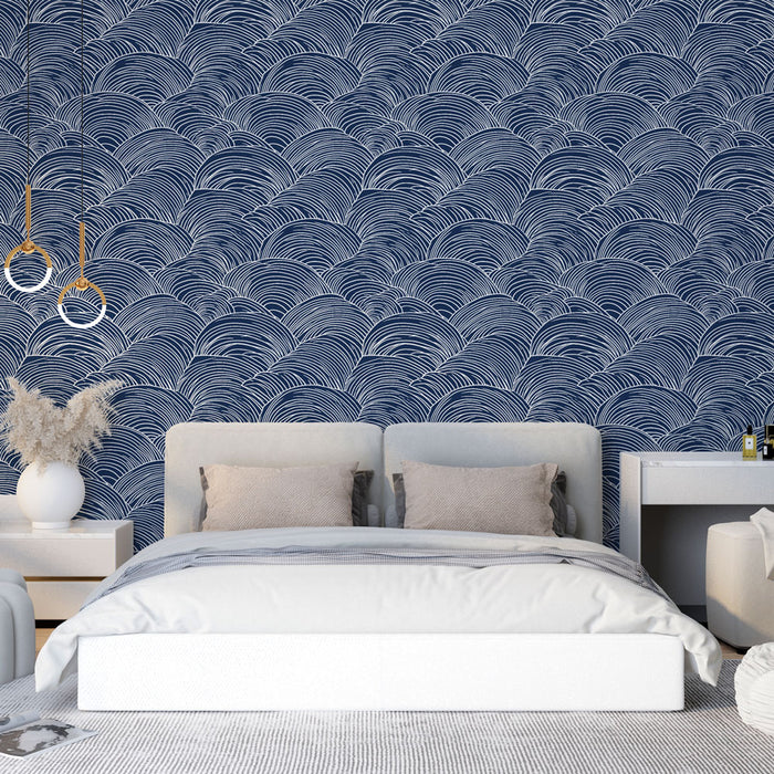 Une chambre moderne avec un papier peint bleu marine orné de motifs ondulés blancs, créant une atmosphère apaisante et élégante.