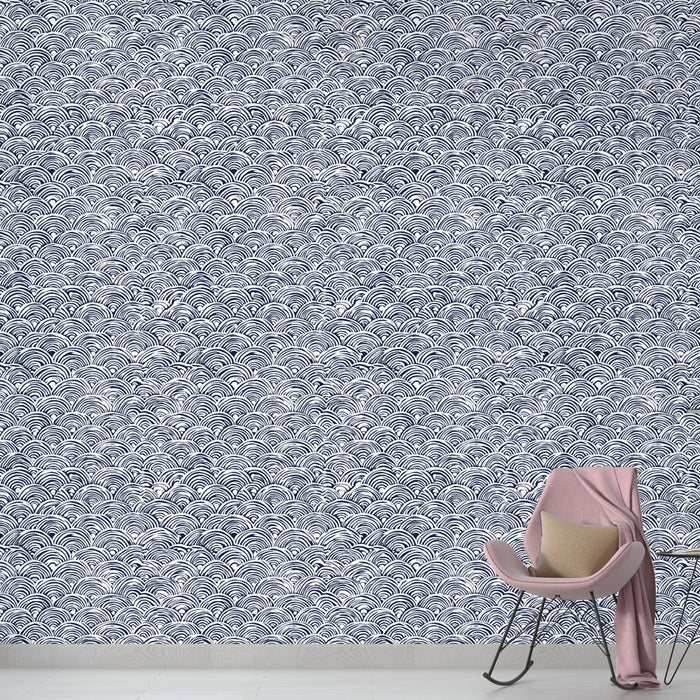 Un salon contemporain avec un papier peint à motifs de vagues en bleu marine et blanc, créant une ambiance dynamique et apaisante.