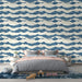 Une chambre moderne avec un papier peint aux motifs de vagues bleues et crème, créant une ambiance apaisante et inspirante.