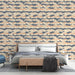 Une chambre moderne avec un papier peint aux motifs de vagues stylisées en bleu marine, beige et touches orangées, créant une atmosphère apaisante et dynamique.