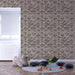 Une chambre d'enfant avec un papier peint aux motifs de vagues stylisées en tons beige et marron, créant une atmosphère douce et apaisante.