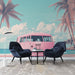 Un salon moderne avec un papier peint représentant un van vintage rose sur fond de plage, évoquant une atmosphère estivale et nostalgique.