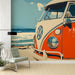 Une pièce moderne avec un papier peint illustrant un combi Volkswagen orange sur fond de plage, évoquant une ambiance rétro et estivale.