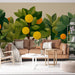 Un salon contemporain avec un papier peint végétal représentant des arbres aux fruits jaunes et des feuilles vertes, créant une ambiance fraîche et accueillante.