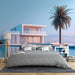 Une chambre moderne avec un papier peint représentant une villa contemporaine au bord de l'eau, évoquant une ambiance sereine et estivale.