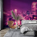Une chambre moderne avec un papier peint urbain aux teintes violettes et roses, représentant une ville animée la nuit, créant une ambiance dynamique et contemporaine.