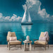 Une pièce lumineuse avec un papier peint représentant un voilier sur une mer turquoise, créant une ambiance apaisante et maritime.
