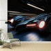 Une pièce moderne avec un papier peint représentant une voiture futuriste noire en mouvement, créant une ambiance dynamique et énergique.