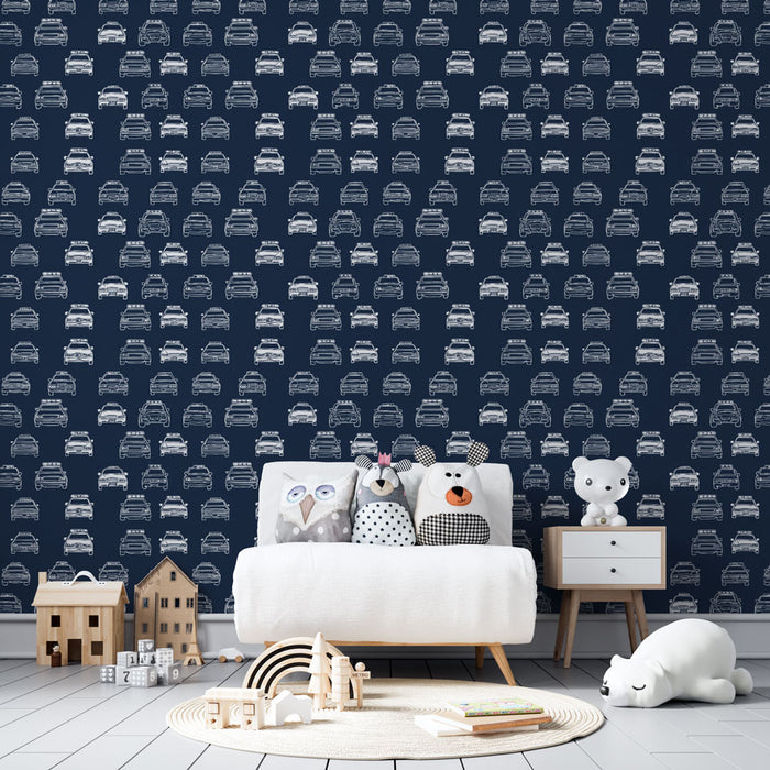 Une chambre d'enfant avec un papier peint bleu marine illustrant des voitures blanches en motifs répétitifs, créant une ambiance ludique et dynamique.