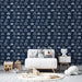 Une chambre d'enfant avec un papier peint bleu marine illustrant des voitures blanches en motifs répétitifs, créant une ambiance ludique et dynamique.