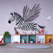 Une chambre d'enfant avec un papier peint illustrant un zèbre volant aux ailes de plumes noires sur fond pastel, créant une ambiance ludique et imaginative.