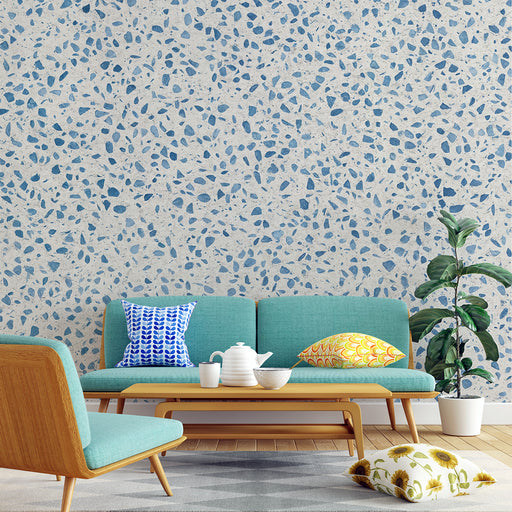 Un salon moderne avec un papier peint texturé beige et bleu, évoquant un style terrazzo, qui apporte une ambiance fraîche et contemporaine.