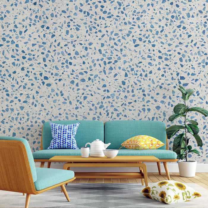 Un salon moderne avec un papier peint texturé beige et bleu, évoquant un style terrazzo, qui apporte une ambiance fraîche et contemporaine.