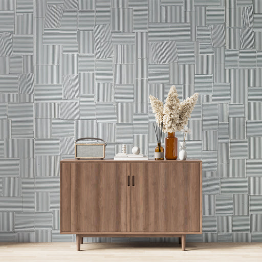 Une pièce moderne avec un papier peint géométrique bleu clair et blanc, aux motifs de lignes et de rectangles, créant une ambiance élégante et contemporaine.