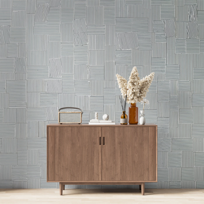 Une pièce moderne avec un papier peint géométrique bleu clair et blanc, aux motifs de lignes et de rectangles, créant une ambiance élégante et contemporaine.