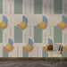 Un salon moderne avec un papier peint géométrique aux formes colorées et harmonieuses, évoquant une ambiance artistique et dynamique.