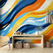 Papier peint mural abstrait avec vagues colorées bleu, orange et jaune pour salon moderne.